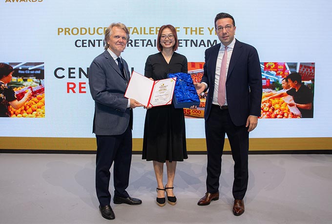 Two business men present a woman with an award