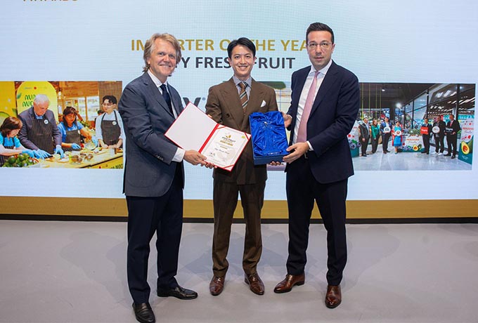 three men stand on stage to receive an award