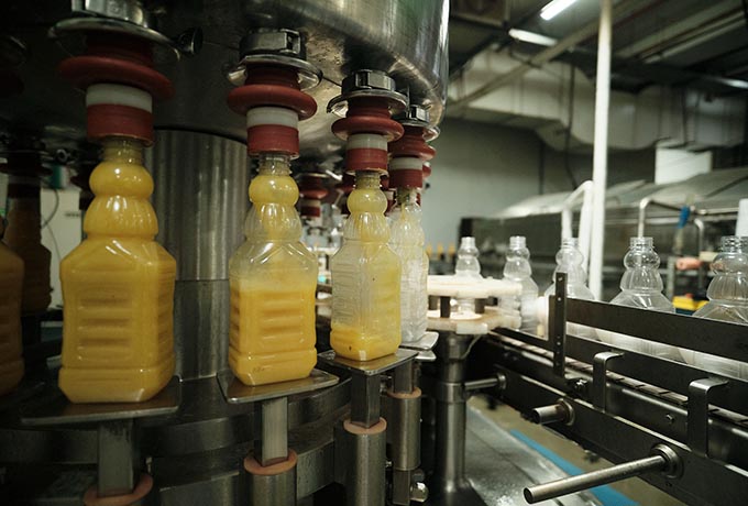 Orange juice bottles being filled through filtration membranes