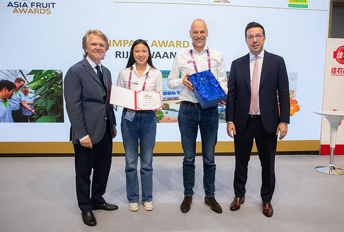 Two business men present an award to a man and a woman