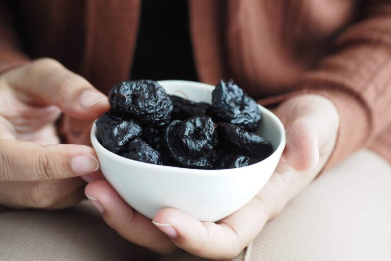  Prunes-for-osteoporosis-in-white-plate-held-by-hands