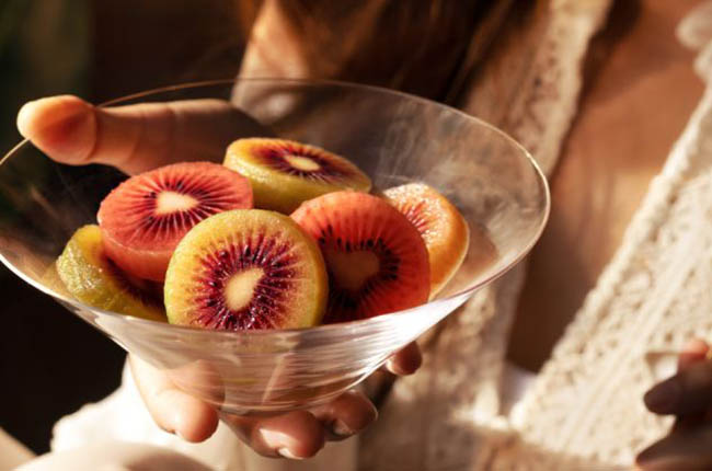 Hand holding bowl with Zespri red kiwi
