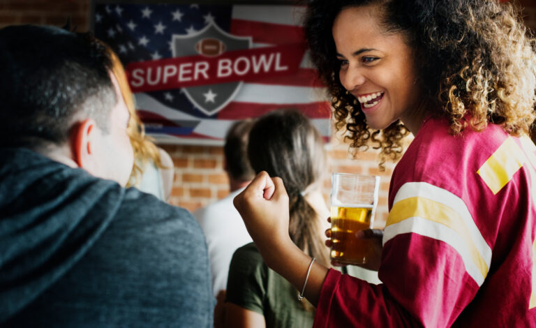 woman watching super bowl and drinking beer
