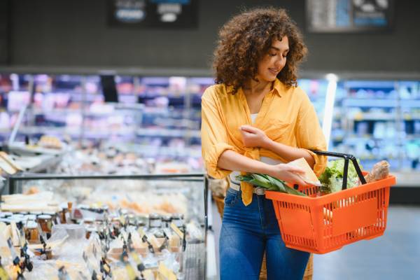 Young woman putting groceries in a basket