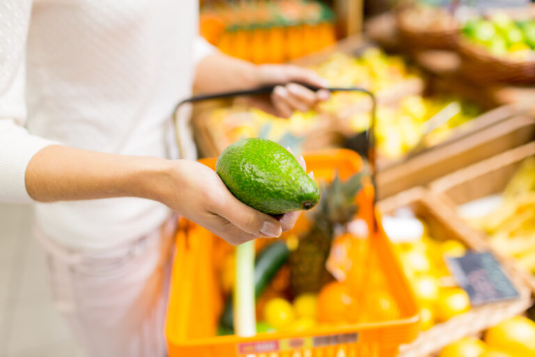 Woman shopping for avocados, probably from the Beta variety 