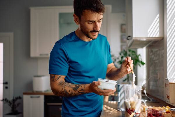 man eating protein-rich greek yogurt